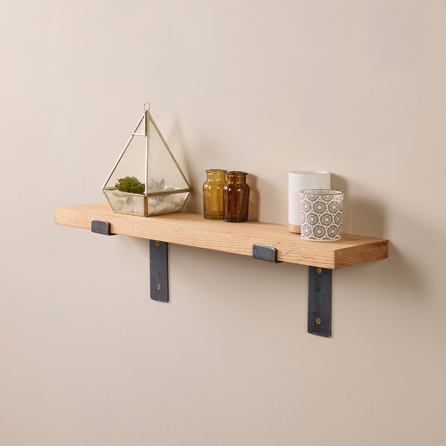 Solid oak shelf with lipped brackets mounted on a kitchen wall