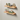 Set of oak floating shelves used for kitchen storage, holding spice jars and cookware.