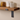 Walnut shelf with lipped brackets installed in a living room, displaying books and plants