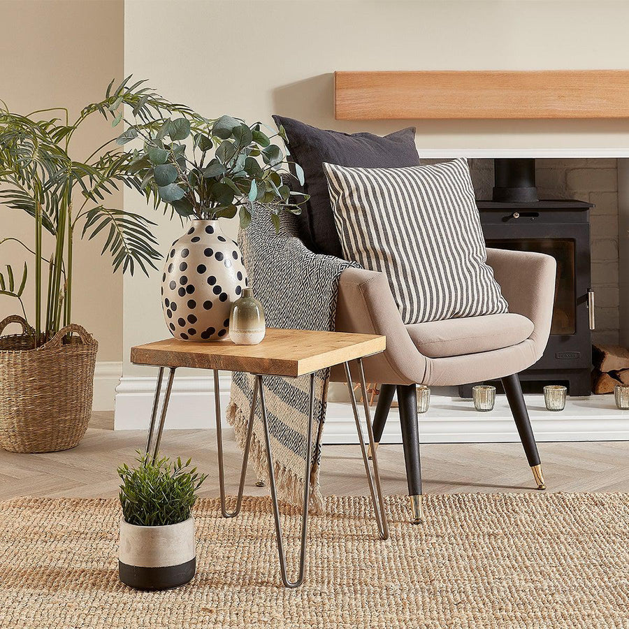 wooden side table next to a open log burner