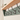 Green coat rack with a solid oak shelf featuring a small candle