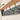 close up image of a painted coat rack with a wooden shelf