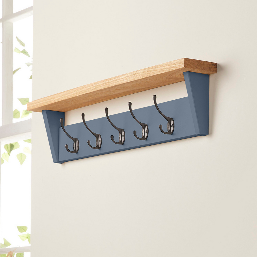 Stiffkey Blue painted wooden coat rack with shelf mounted on wall.