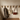 Wooden hooks on a wall with a coat, bag, and purse hanging from them.