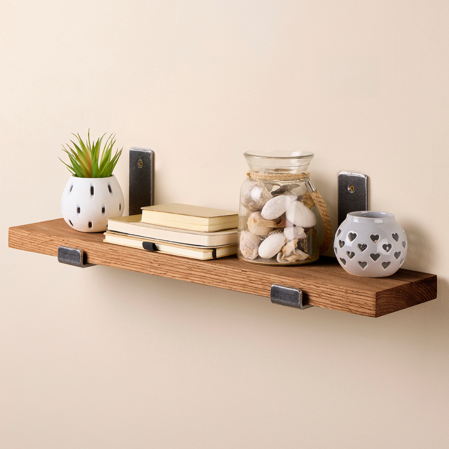 dark oak shelf with brackets styled with books and décor