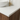 Bathroom vanity with white countertop, wooden cabinet, and gold faucet.