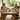 Family of four sitting at a wooden dining table outdoors, enjoying a meal.