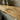 Close up of the curved oak bracket supporting the narrow oak shelf, showing the grain