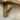 Narrow solid oak shelf on two curved wooden brackets on a plain white background