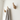 Wooden wall hooks with a striped towel on a white wall