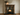 Victorian pine fire surround in dark wax finish, grain and corbel detail visible, installed above wood burning stove