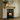 Styled pine corbel mantel shelf with candles, a mirror and framed photos in a living room