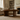 round wooden coffee table in a living room with a sofa and bookshelf in the background.