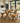 rustic pine dining table and bench set with x frame legs in bright dining room with natural light and garden view