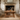 rustic wooden coffee table in front of a stone fireplace with decorative items.