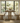 solid oak dining table and benches with T leg base in a bright room with large windows.