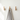 Three wooden wall hooks with a towel hanging on one of them against a white wall.