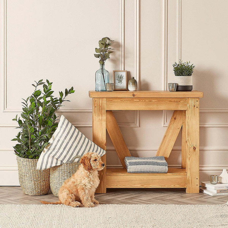 wooden console table with plants and a dog 